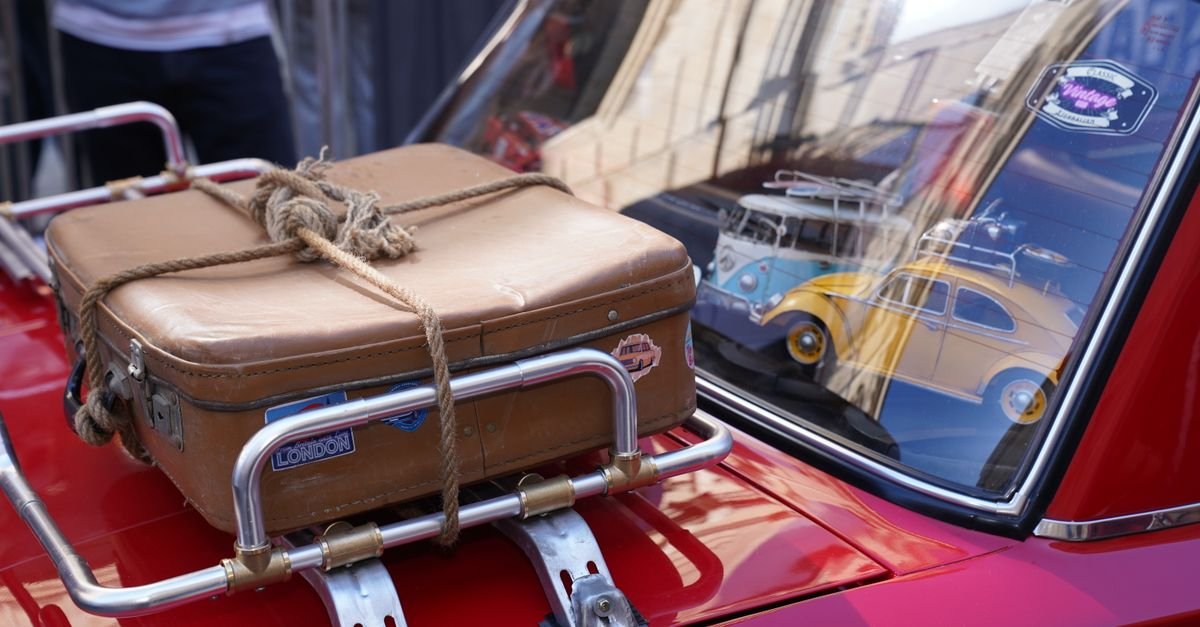 A suitcase being loaded into a car boot