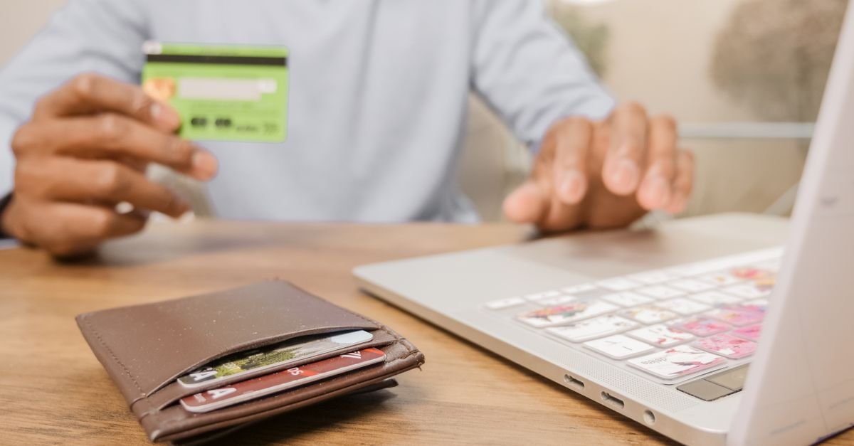 A credit card beside a laptop