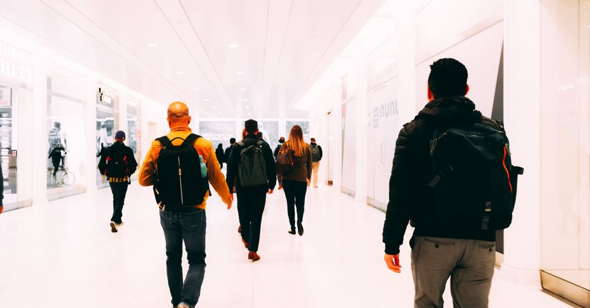 A traveller hurrying through an airport with a backpack