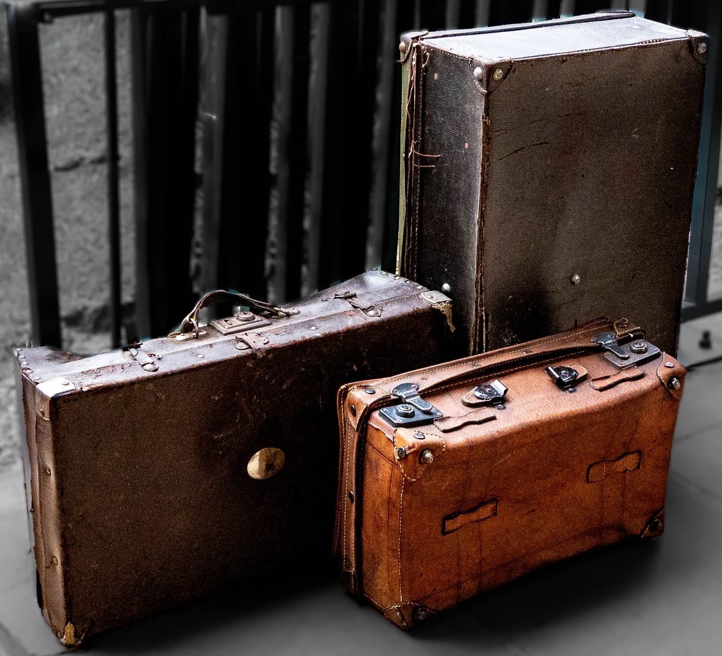 Two battered vintage suitcases with scuffed corners and worn leather