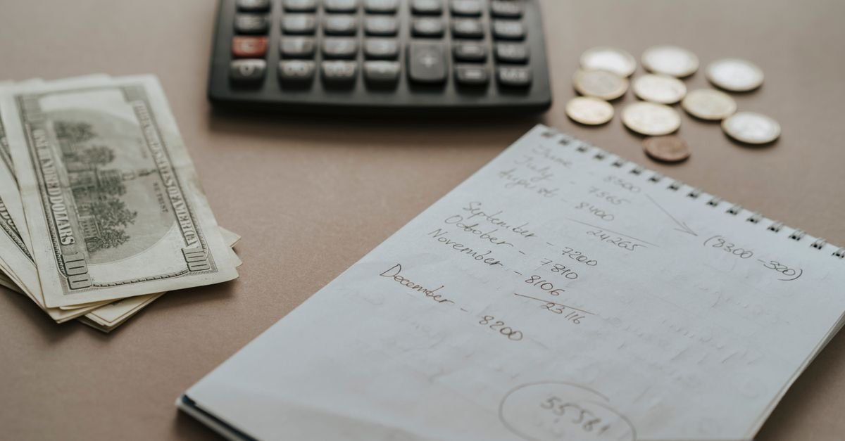 A notebook with budget calculations beside a coffee