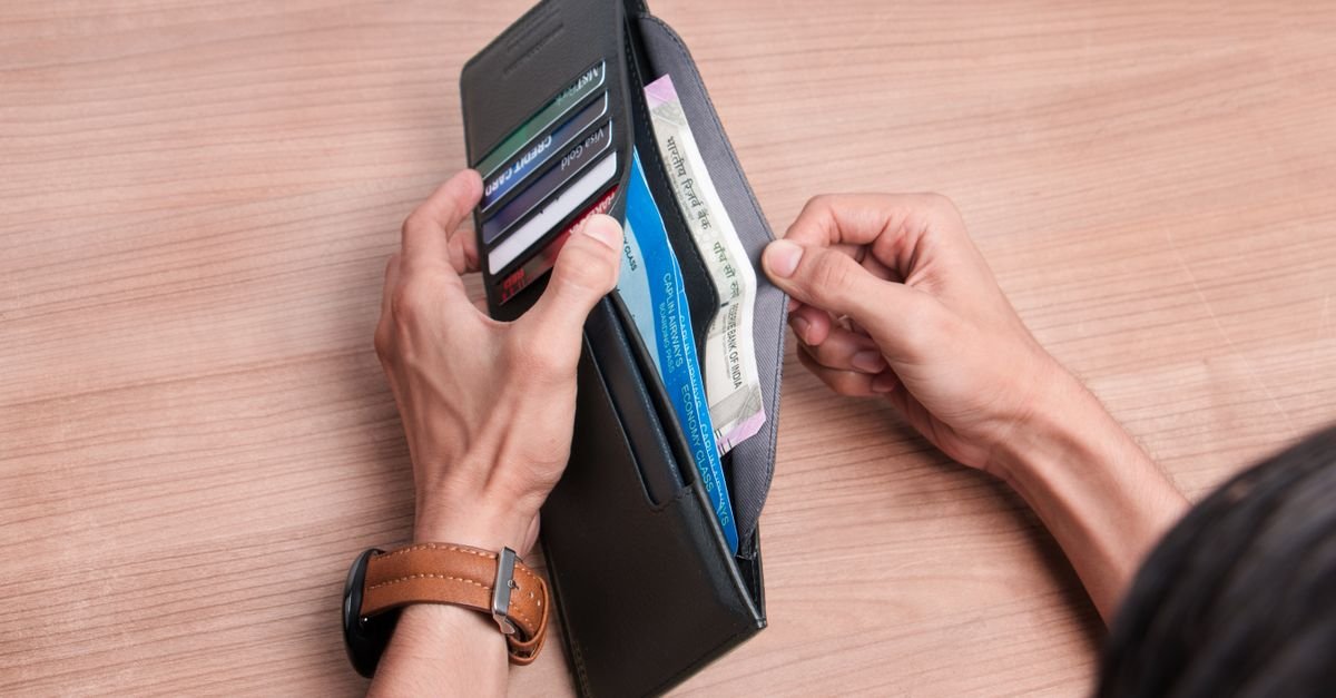 A wallet with cash and cards on a table