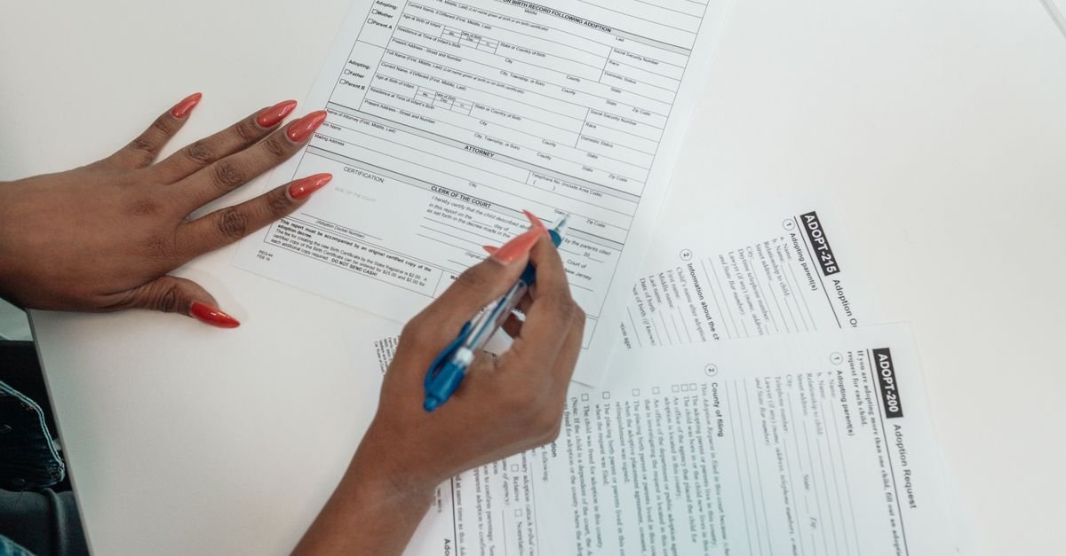 A person completing paperwork at a desk